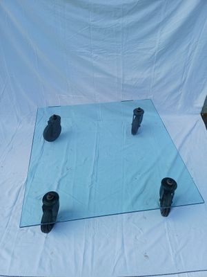 a glass table with four black candles on it
