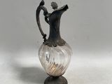 un vase en argent et en verre orné d'un oiseau