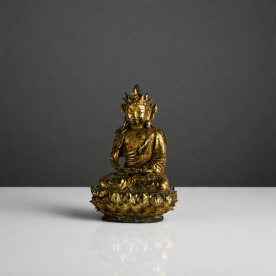 a gold buddha statue sitting on top of a white table