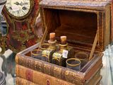 une petite boîte en bois contenant des bouteilles, posée sur une table en verre