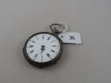 a silver pocket watch with roman numerals on it