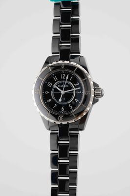 the black ceramic watch is displayed against a white background