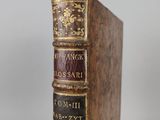 an old book sitting on top of a wooden table next to a white wall