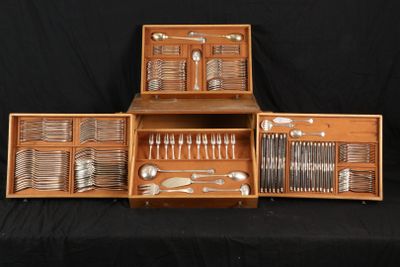 a lot of silverware in a wooden box on a table