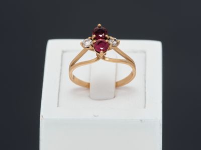 a close up of a gold ring with a red stone
