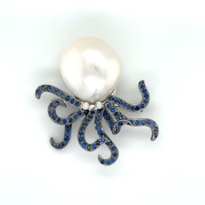 an octopus brooch with a pearl and blue sapphires