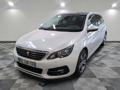 La voiture blanche est garée sur le sol à damier du garage.