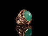 l'image d'une bague en or ornée d'une pierre verte