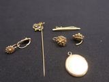 quelques bijoux en or et en argent posés sur un fond noir