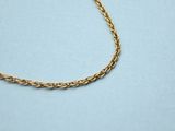 a gold chain necklace on a blue surface