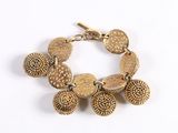an image of a gold bracelet with five small shells on it