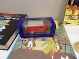 a toy car in a box on a table next to a book