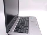 a silver laptop with a black keyboard on a white surface