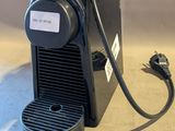 une petite machine à café noir posée sur une table