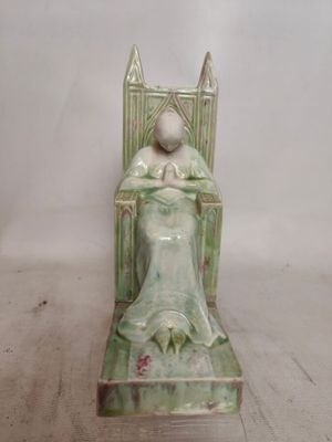 a figurine of a woman sitting in a chair