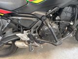 a motorcycle parked in a garage with a red, yellow, and green stripe on it