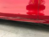 the red car is parked on the side of the road with its door open