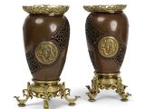 deux vases marron posés l'un sur l'autre sur une surface blanche