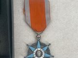 a small medal with a star on it next to a black box