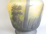 un vase avec un tableau posé sur une table