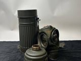 an old gas mask and a canister on a black cloth