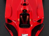 the top view of a red race car parked on a black surface