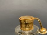 a small glass jar with a gold lid on a table