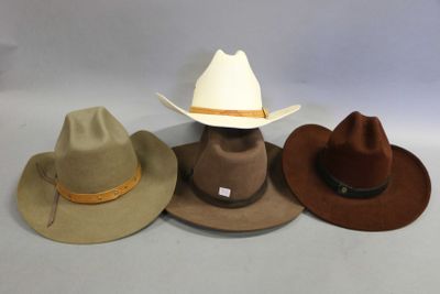 three hats are lined up on a table with a white background