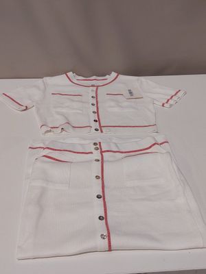 doll ' s white dress with red trim and buttons on a white table