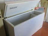 a white chest freezer sitting in a kitchen next to a refrigerator