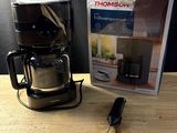 une cafetière posée sur une table à côté d'une boîte