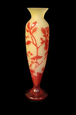 a red and white vase sitting on a black surface