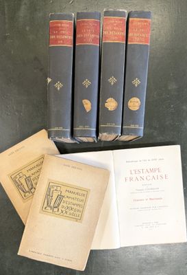 three books are sitting on a table next to a stack of books