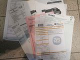 a pile of papers sitting on the floor next to a cell phone