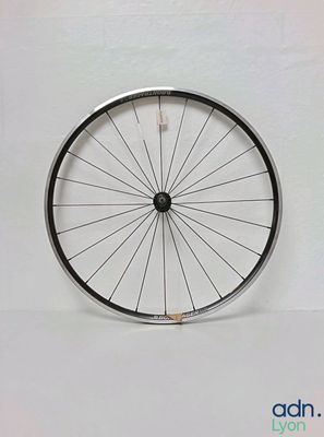 a bicycle wheel that is sitting on a white surface