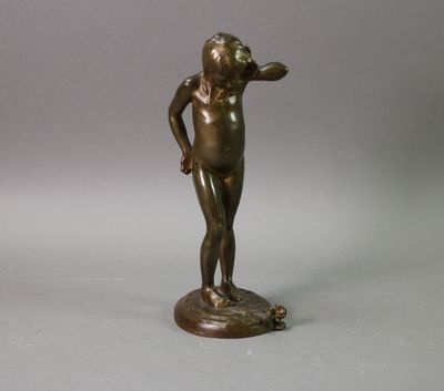 une statue antique en bronze représentant un jeune garçon sur un socle