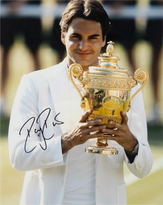 photo dédicacée d'un joueur de tennis tenant un trophée sur un court de tennis
