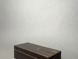 a small wooden box with a lid on a grey background