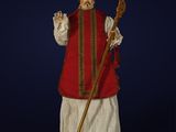 une image représentant une figurine d'un homme vêtu d'une tenue rouge et blanche et muni d'une canne