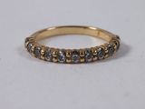 a close up of a gold ring with grey diamonds on it