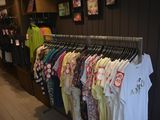 a lot of shirts hanging on a rack in a store