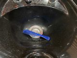 a black sink with a blue toothbrush in it