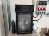a small refrigerator sitting on a small table in a room