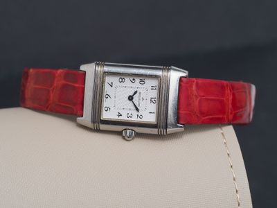 une image représentant une montre avec un bracelet rouge