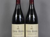 deux bouteilles de vin posées sur une table l'une à côté de l'autre