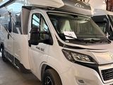 deux camping-cars blancs garés dans un garage