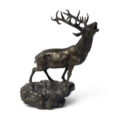 sculpture en bronze représentant un cerf debout sur un rocher, avec ses bois