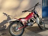 a red dirt bike parked on the sidewalk in front of a building