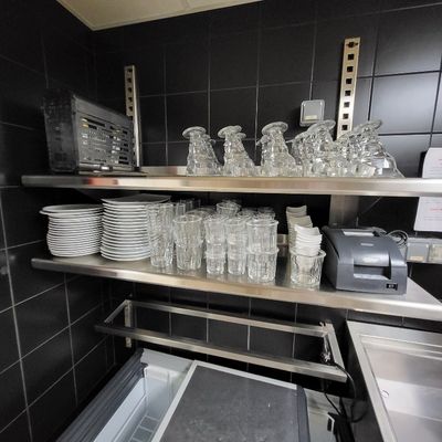 une cuisine avec beaucoup de vaisselle et de verres sur les étagères