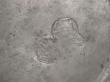 an old silver plate with a picture of a man and a woman on it